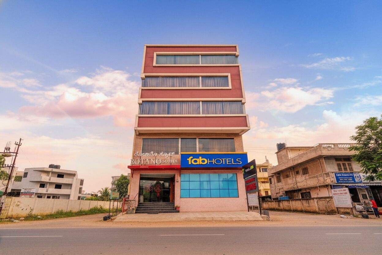 Un hôtel à plusieurs étages, doté d’une façade sobre, d’une enseigne bien visible indiquant « fab hotels » et d’une entrée clairement identifiable avec des marches.