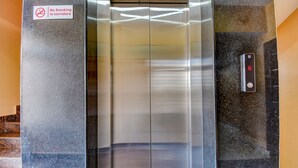 An elevator with a no-smoking sign and a digital display showing 'G'. - Fabhotel Rotano Suites (Bengaluru)