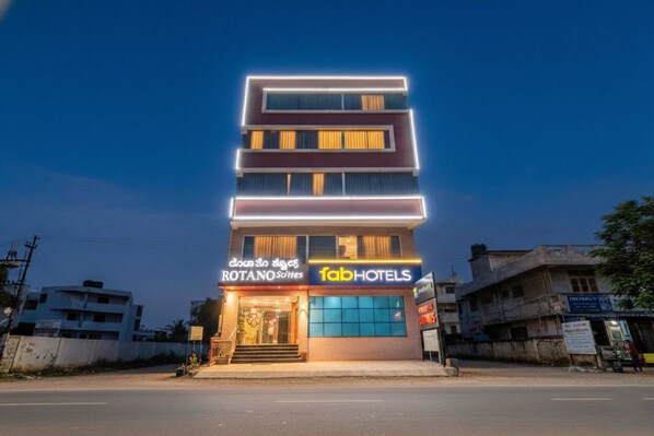 A multi-story building with a sign for 'fab hotels' and 'rotano hotels'. - FabHotel Rotano Suites (Bengaluru)