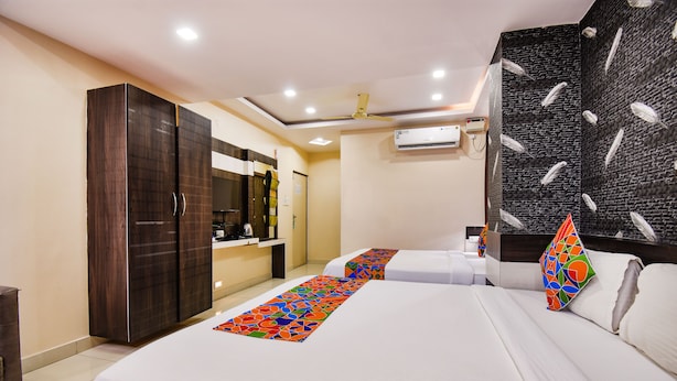 A hotel room with two beds, a wardrobe, a desk, and a bathroom. - Fabhotel Rotano Suites (Bengaluru)
