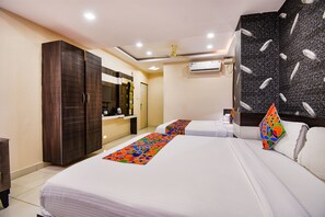 Een hotelkamer met twee bedden, een kledingkast, een bureau en een badkamer.