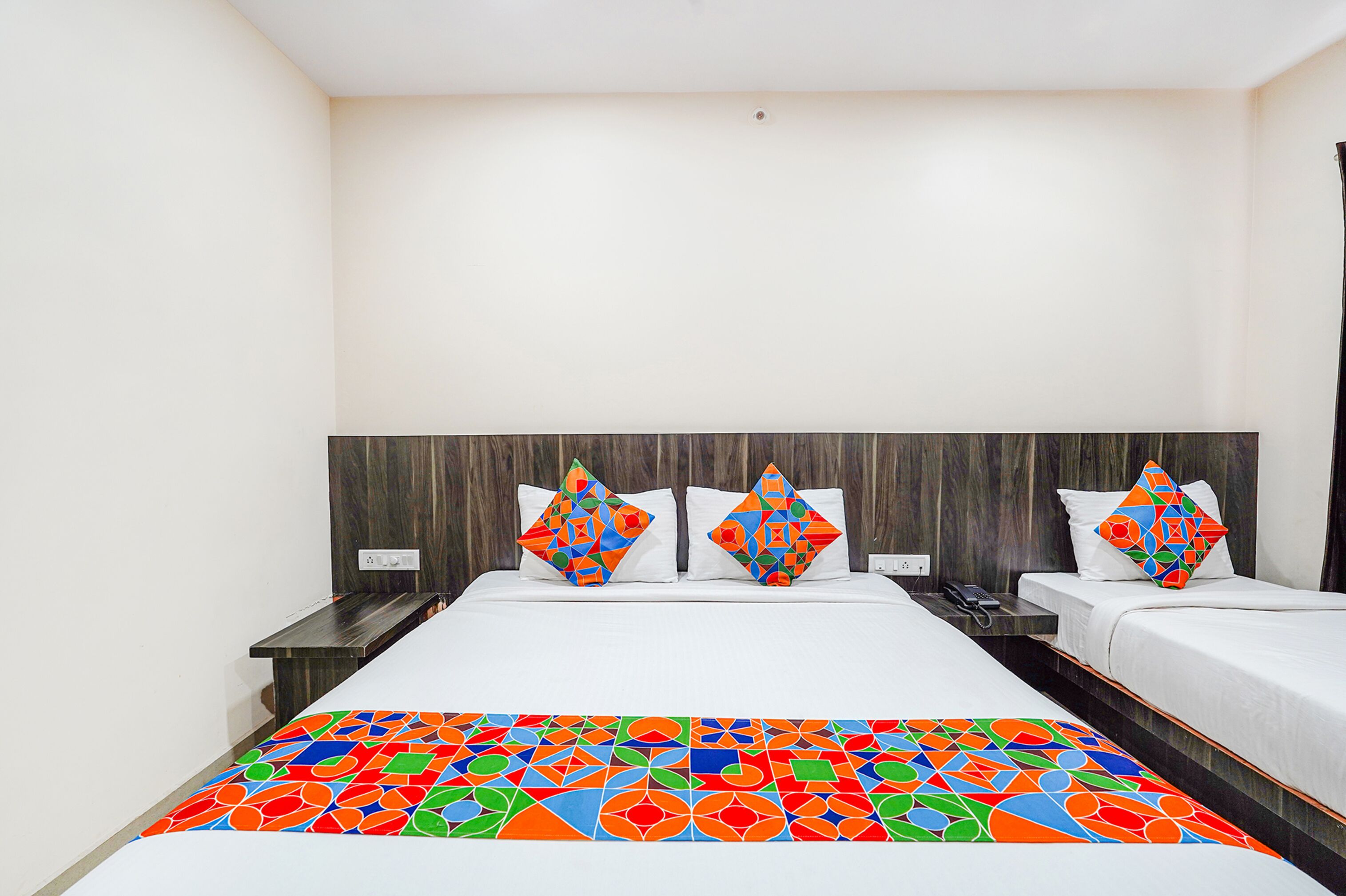 Quarto de hotel com uma cama grande, duas mesas de cabeceira e uma cabeceira.
