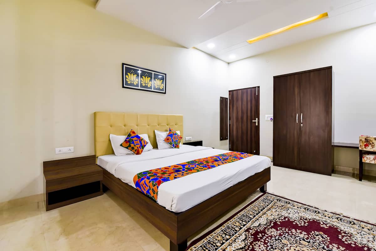 A bedroom with a bed, a nightstand, a wardrobe, and a ceiling fan.