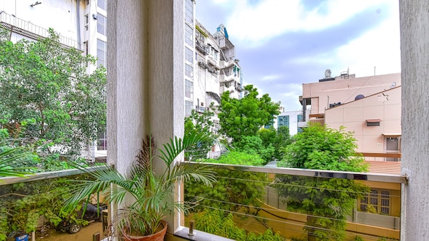 A balcony with potted plants, a small artificial grass area, and a view of neighboring buildings. - Fabhotel The Castle Homestay (Jaipur)