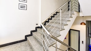 A staircase with metal railings and granite steps, leading to an elevator. - Fabhotel The Castle Homestay (Jaipur)