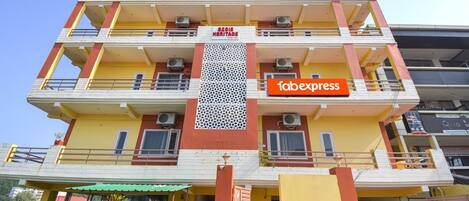 A multi-story building with balconies, air conditioning units, and a sign for 'fabexpress'.