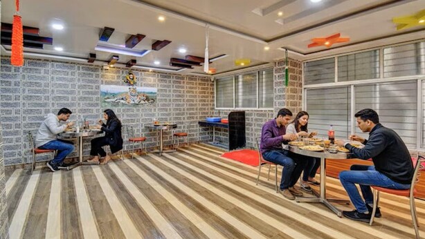 Un comedor con paredes de ladrillo, piso a rayas e iluminación moderna en el techo.