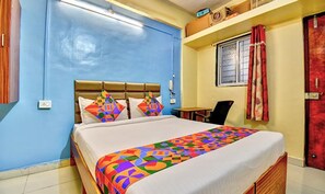 Quarto com cama, escrivaninha e janela.
