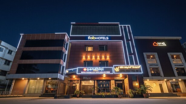 A multi-story building with 'fabHOTELS' and 'pandhini' signs, featuring a modern facade with large windows and a flat roof. - Oriva Suvee Boutique (Bengaluru)