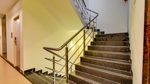 Una escalera con barandillas de metal y escalones de mármol en un edificio.