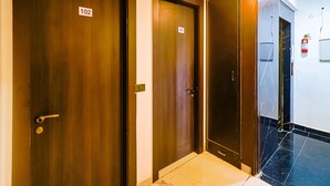Un pasillo con tres puertas, cada una con un número: 102, 101 y 103.