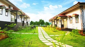 A courtyard with two-story buildings, a central pathway, and small trees. - FabHotel Vagator Retreat Resort With Swimming Pool - Nr. Chapora Fort (Vagator)