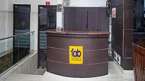 A reception area with a curved counter, a ceiling fan, and a sign for 'Tab Hotels'. - Fabhotel Arihant Inn (New Delhi)