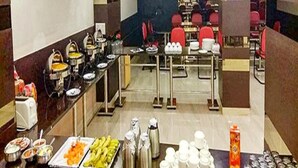 A buffet setup with various food items and utensils. - Fabhotel Arihant Inn (New Delhi)