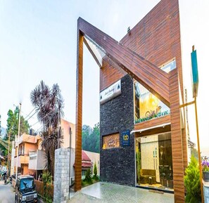 A modern hotel with a prominent wooden facade and a stone accent wall. - Fabhotel Sholas Residency I (Ootacamund)