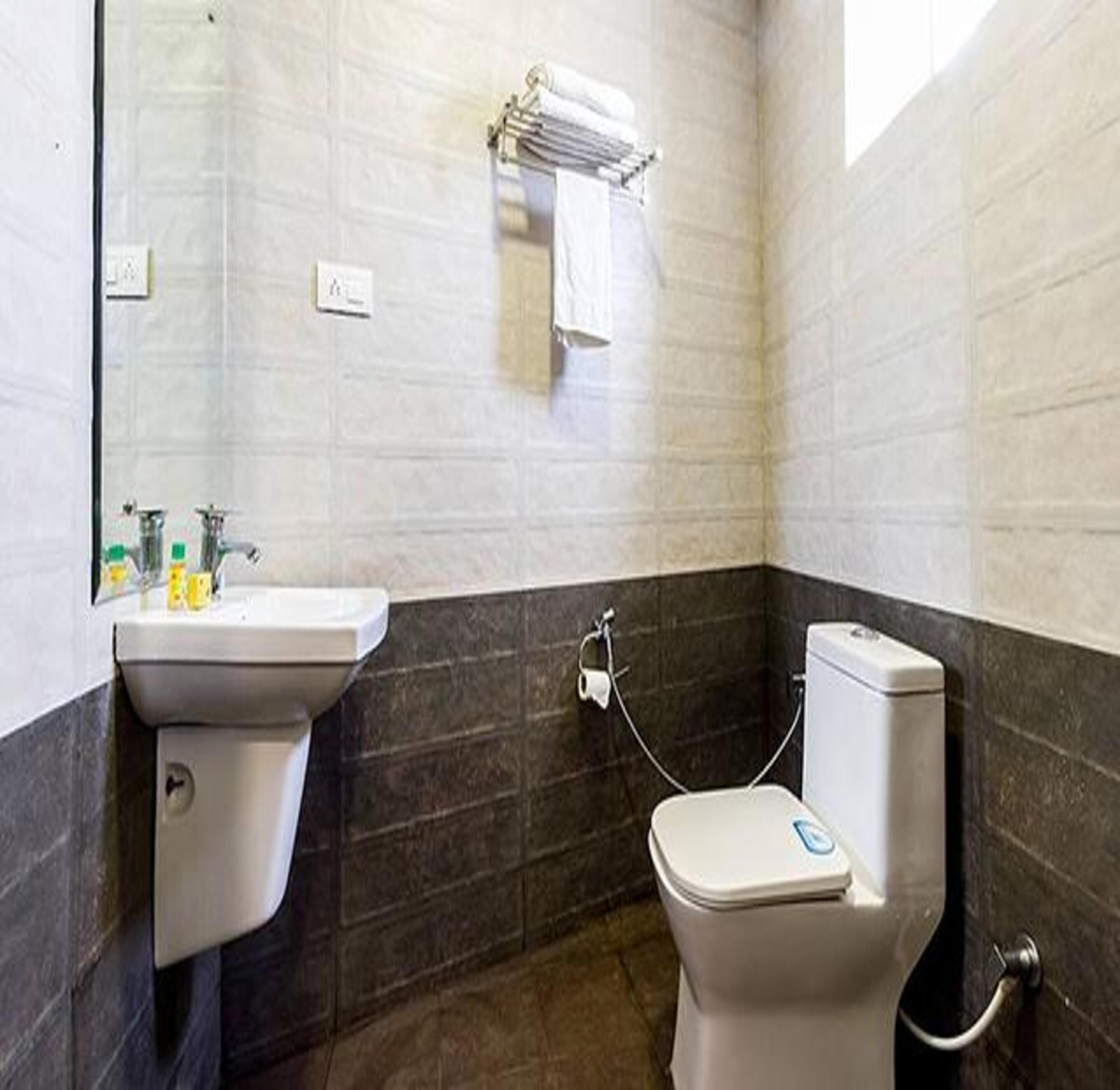A bathroom with a sink, toilet, and towel rack.