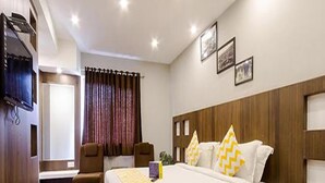 Une chambre d’hôtel avec un grand lit, un bureau, une chaise et un téléviseur.