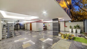 A modern lobby with a marble floor, a staircase, and potted plants. - Fabhotel Exotica (New Delhi)