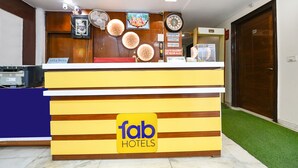 A hotel reception desk with a 'fab hotels' sign, a clock, and a framed picture above the counter. - FabHotel Baba Residency (New Delhi)