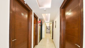 A hallway with wooden doors, numbered 207 and 201, leading to a kitchen area. - FabHotel Baba Residency (New Delhi)