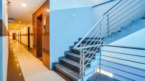 A modern hotel corridor with a marble staircase and metal handrails. - Fabhotel Shreyas Inn (Bengaluru)