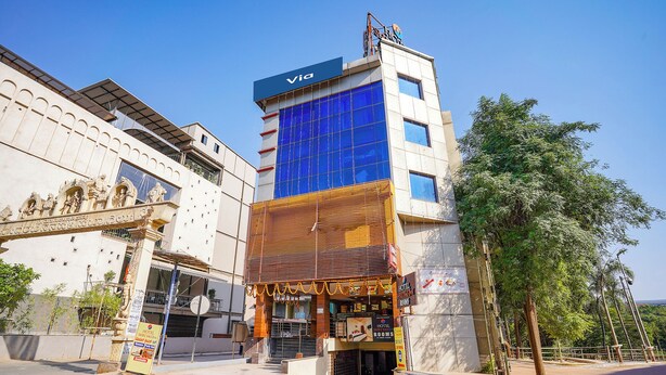 A hotel with a modern facade, a sign for 'Hotel Shreyas,' and a 'Via' sign on top. - Fabhotel Shreyas Inn (Bengaluru)