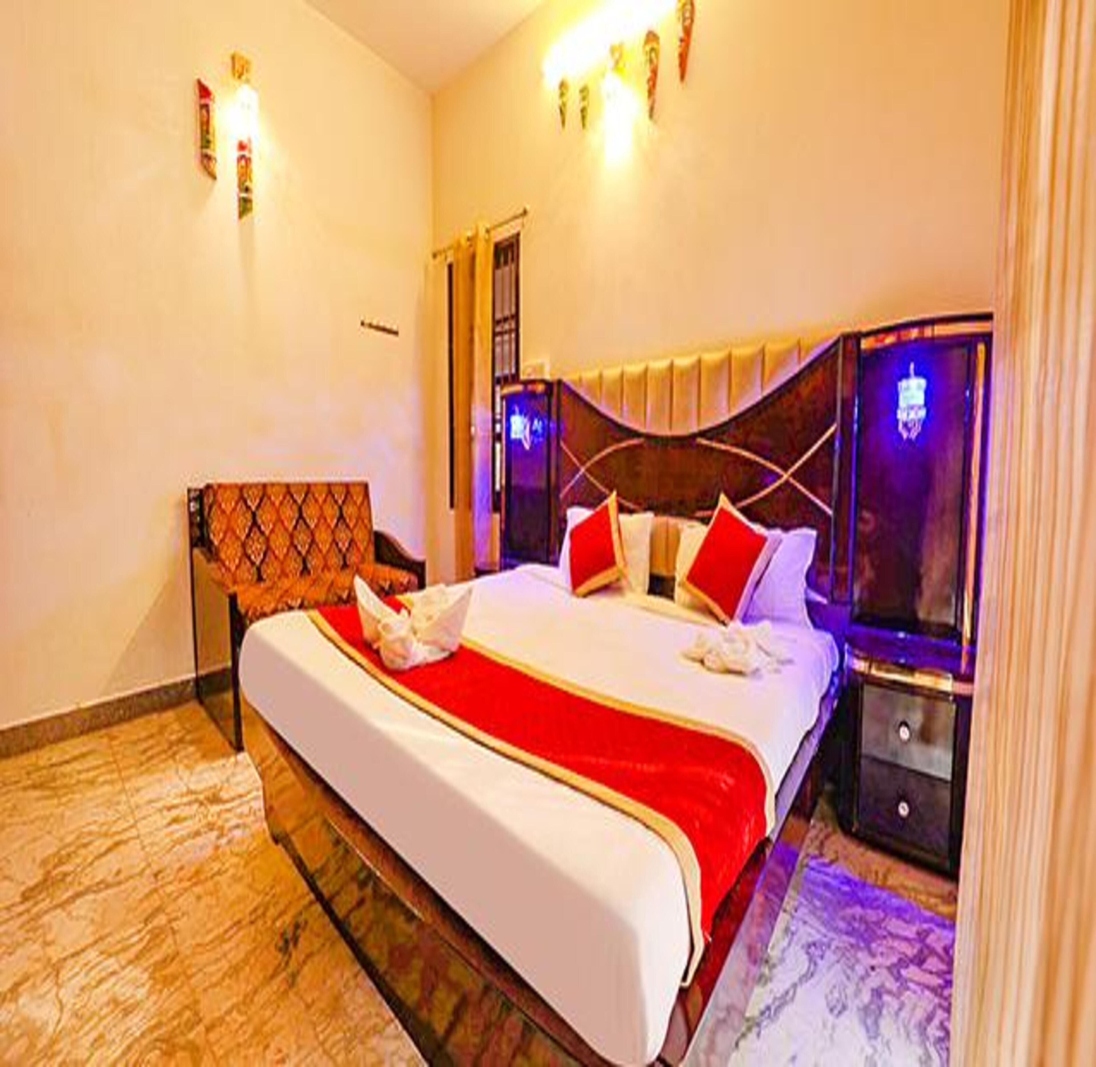 A hotel room with a large bed, a nightstand, and a mirror.