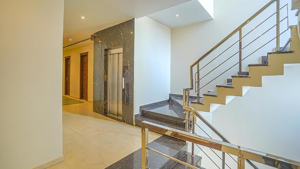 Un intérieur moderne avec un escalier, un mur en marbre et une porte.
