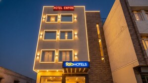 Un hôtel moderne, reconnaissable à son enseigne où l’on peut lire « HÔTEL EMPIRE » et « fabHOTELS ».