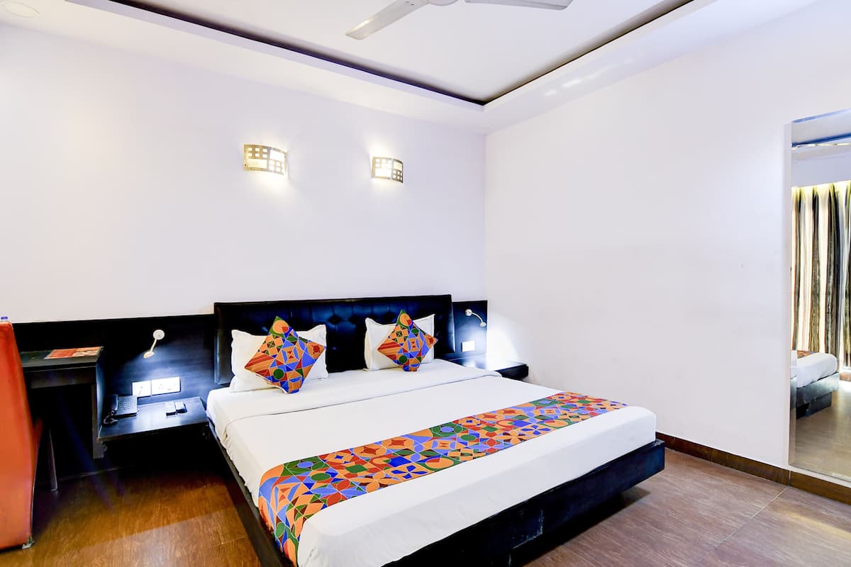 Une chambre d’hôtel moderne avec un grand lit, un bureau et une table de chevet.
