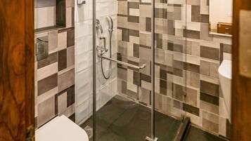 Ein modernes Badezimmer mit Duschkabine aus Glas, gefliesten Wänden und einer weißen Toilette.
