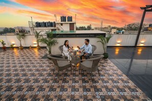 A rooftop terrace with patterned flooring, wicker furniture, and potted plants. - FabHotel La Paz Stay B&B (New Delhi)