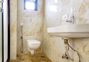 A bathroom with a marble floor, a toilet, a sink, and a shower. - Fabhotel Eros 211 (Bidhannagar)