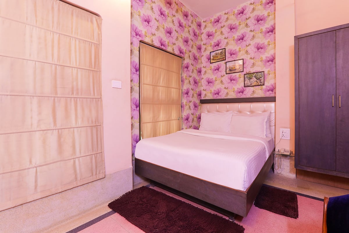 A bedroom with a bed, a wardrobe, and a door.