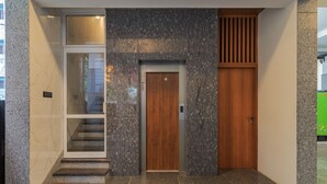 A modern elevator with a wooden door and a glass panel above it.