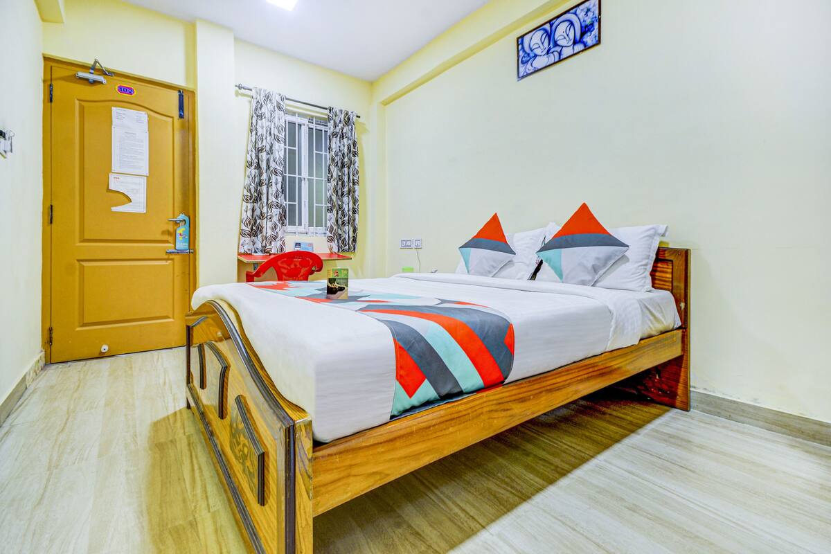 Un dormitorio con una cama de madera, una puerta con un cartel, una ventana con cortinas y un cuadro en la pared.