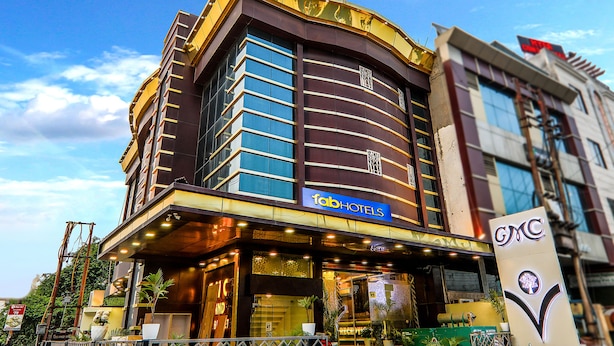 Un hôtel à la façade moderne, avec une enseigne bien visible indiquant « Fab Hotels » et le logo GMC.