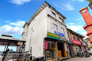 A building with multiple shops including a restaurant, a clock tower, and a sports store. - Fabhotel Clock View - Near clock tower (Dehradun)