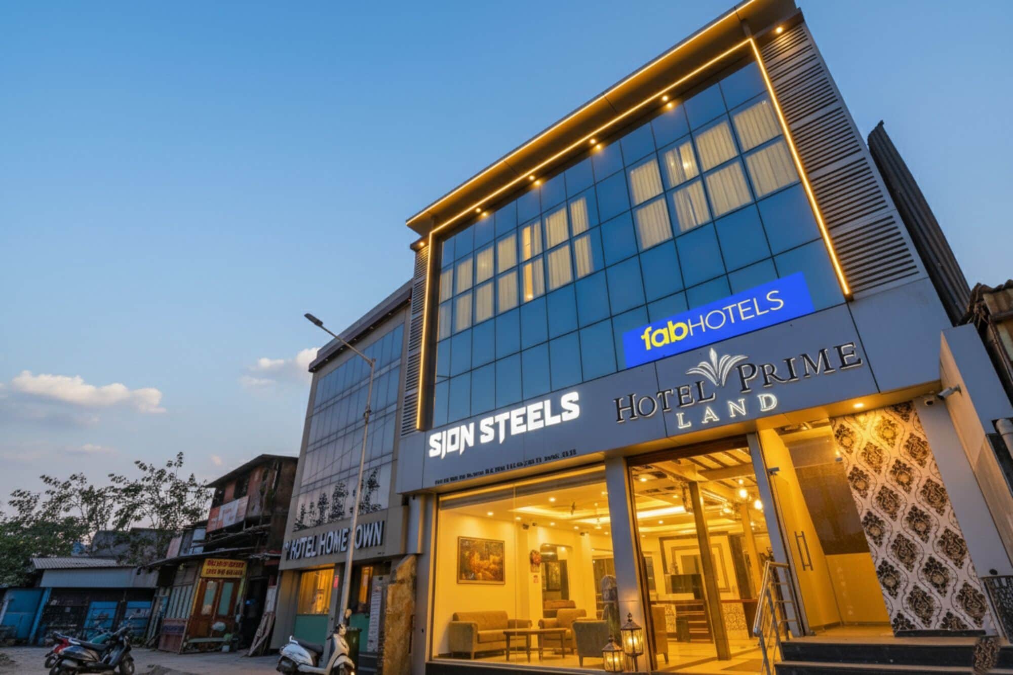 A hotel named 'Sion Steels' with a 'fabHOTELS' sign, featuring a modern facade and a visible entrance.