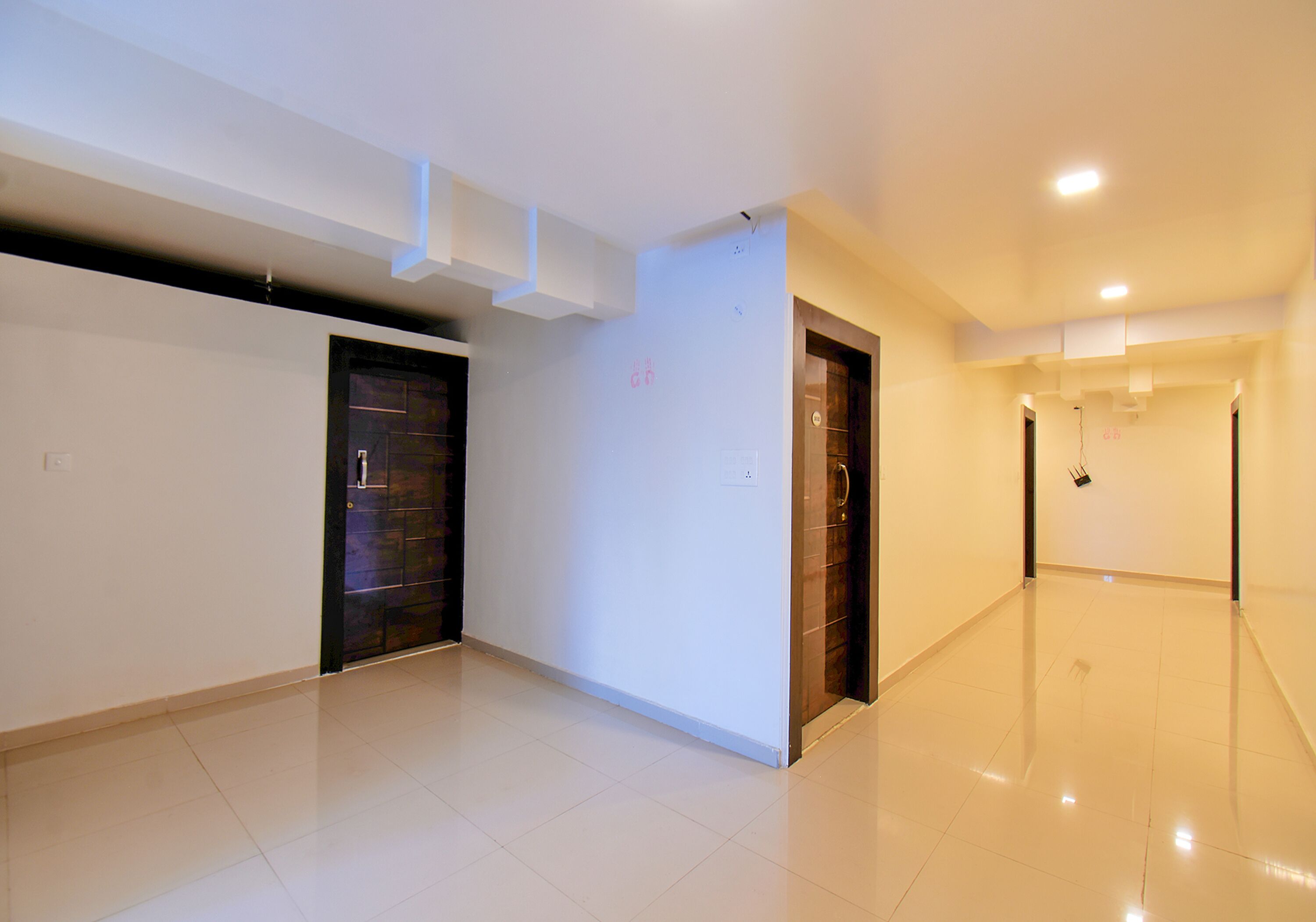 A spacious, well-lit hallway with a clean, tiled floor and modern doors.