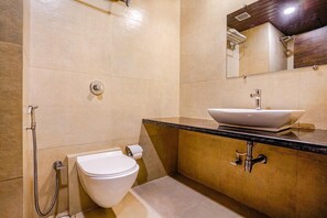 A modern bathroom with a toilet, bidet, sink, and mirror. - Fabhotel Vertigo Suite (Mumbai)