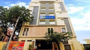 A multi-story hotel with a 'fabHOTELS' sign, a visible entrance, and a banner advertising 'Surya Grand' and 'Banquet Hall'. - Fabhotel Surya Grand I (Vijayawada)