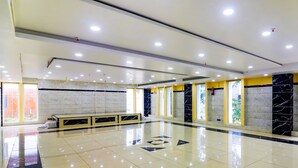 A spacious, well-lit lobby with a marble floor, benches, and large windows. - Fabhotel Surya Grand I (Vijayawada)