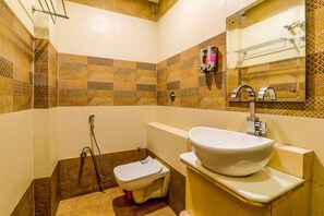 A bathroom with a white sink, a toilet, and a shower.