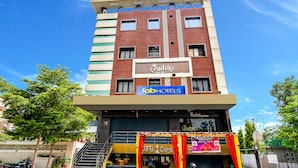 A multi-story building with a sign for 'FabHotels' and 'Rudra Desi'.