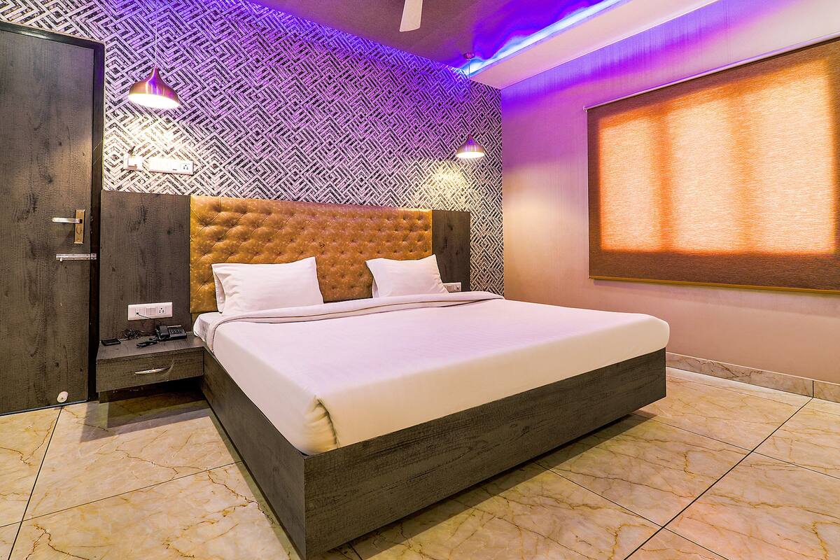 Quarto moderno com uma cama grande, um guarda-roupa e uma parede estampada.