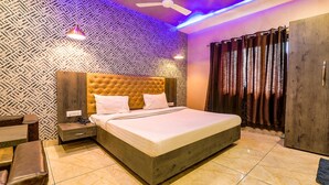 A modern bedroom with a large bed, a nightstand, a wardrobe, and a ceiling fan.