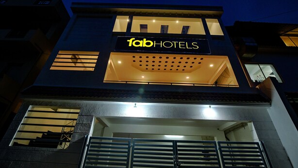 A modern building with a sign reading "fabHOTELS" and a balcony with railings. - FabHotel Greenwood Stays (Ootacamund)