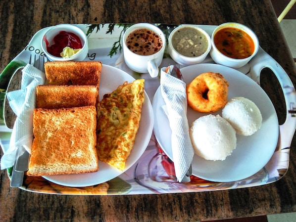 A tray with toast, a fried egg, white rice, a donut, and various sauces. - FabHotel Rushank Palace - Near Jawahar Circle, World Trade Park (Jaipur)