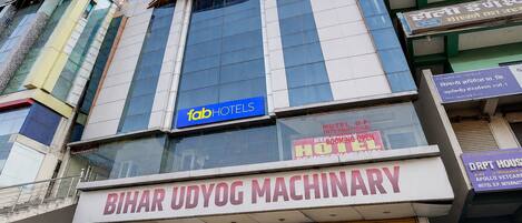 Un edificio con un cartel que indica 'fabHOTELS' y 'Bihar Udyog Machinery' en la planta baja.
